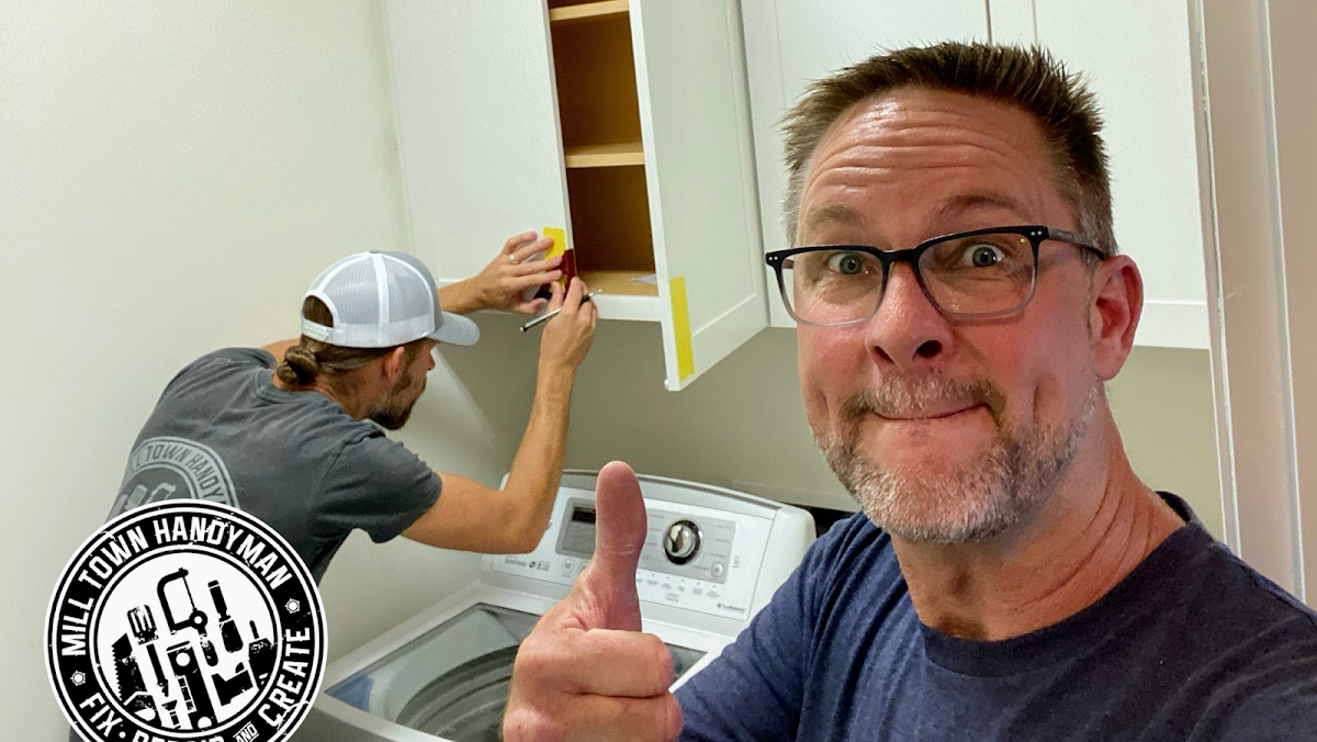 Bill giving a thumbs up while a Mill Town Handyman crew member installs a cabinet