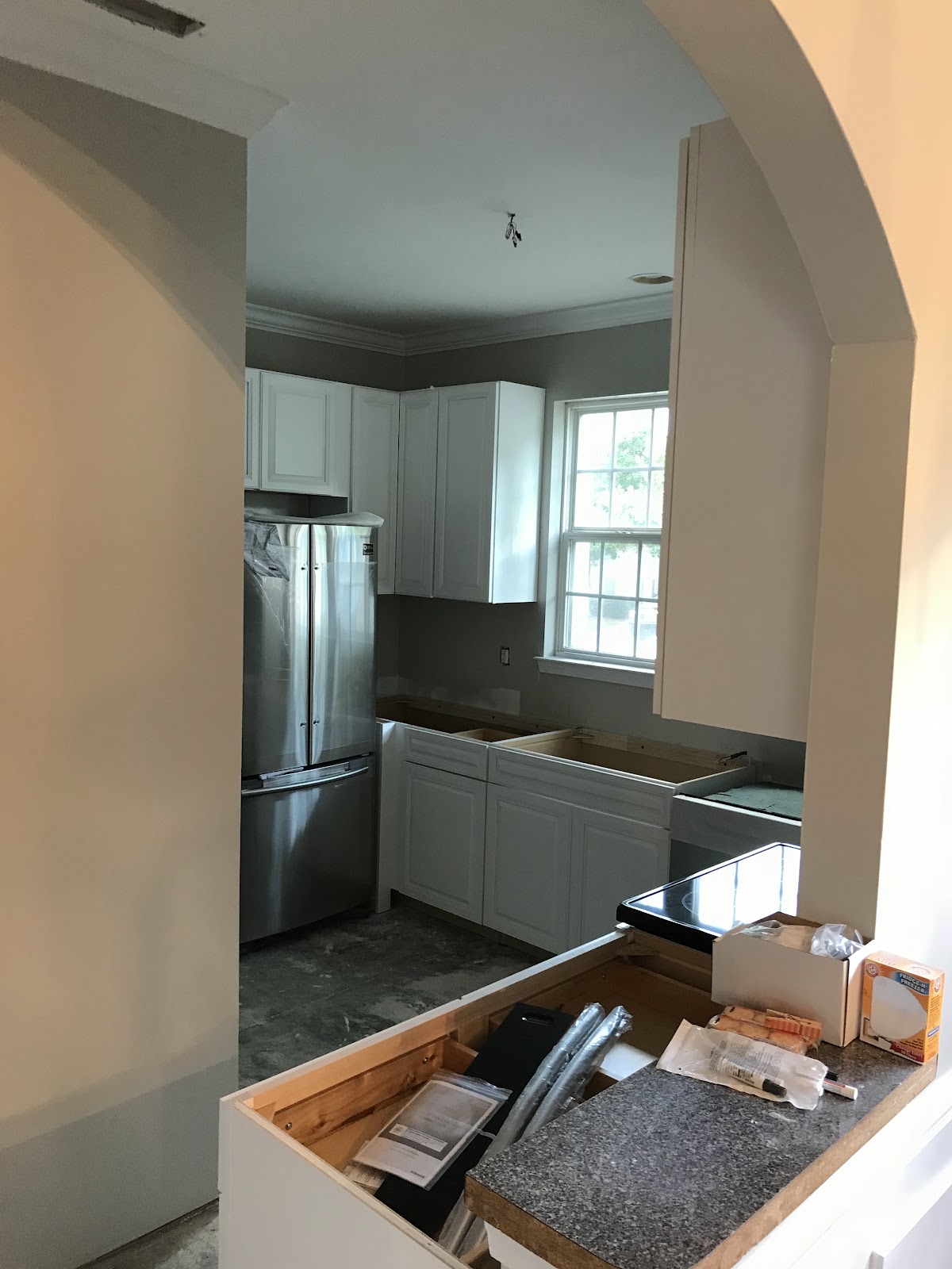 Kitchen with new white cabinets seen through an archway